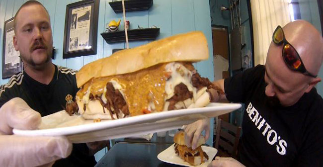 Jerret Ulmer of HeadAddicts.com and Scott Roberts trying the Inferno Sandwich Challenge from De.Lish Cheesecake Cafe